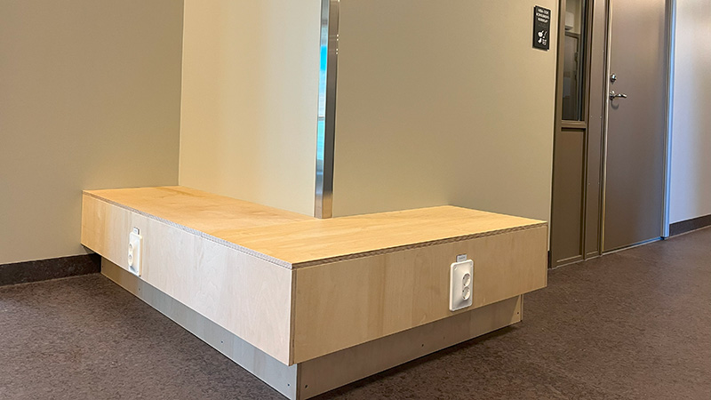 Träbänk mot vägg.