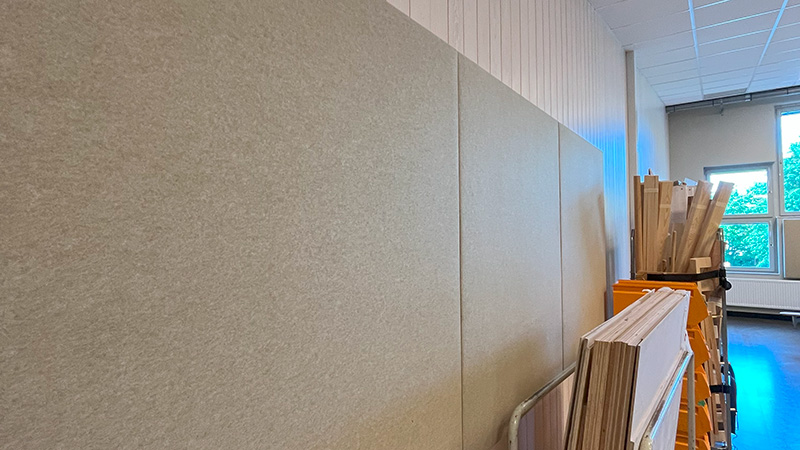 Tygklädda plattor på vägg.