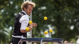 Man som jonglerar med bollar på en studsmatta