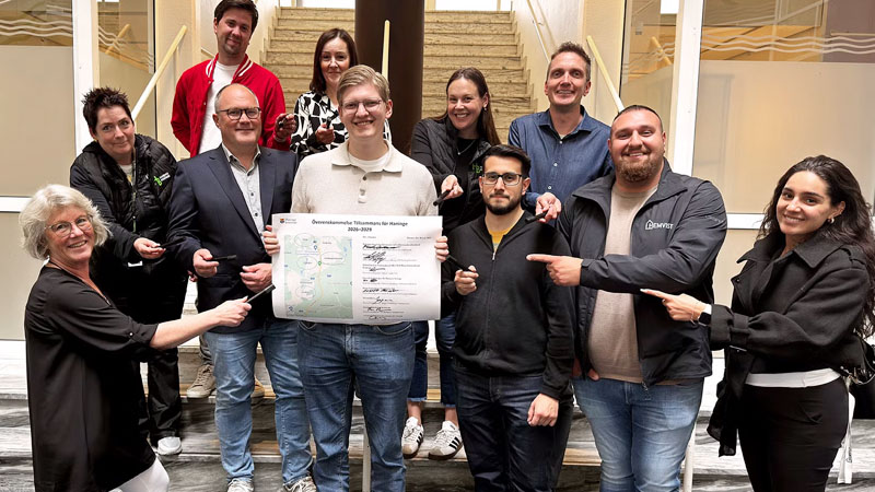 Gruppbild på flera personer som står i en trappa i kommunhuset.