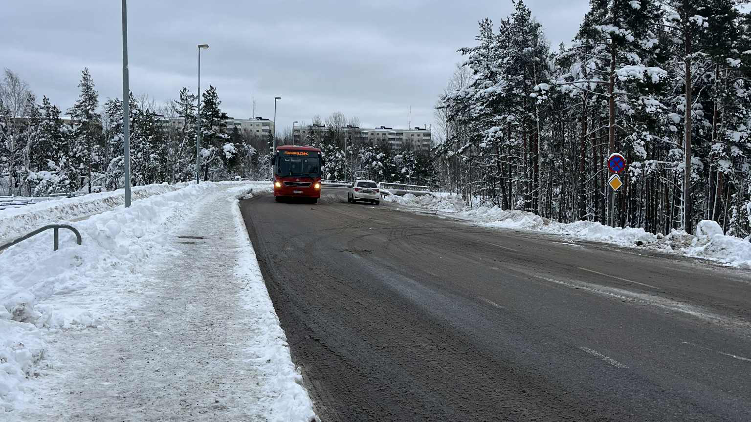 Snöig väg med buss och bil