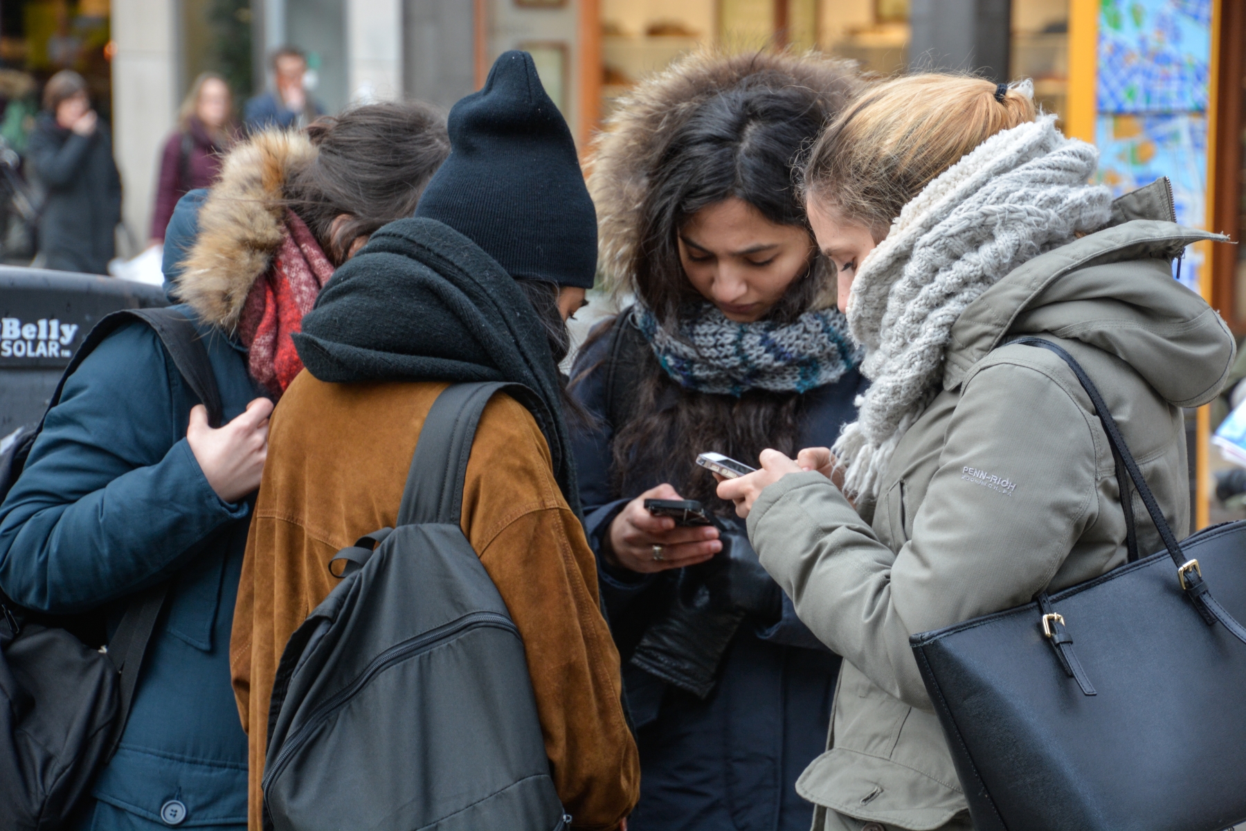 En grupp ungdomar som tittar i sina mobiltelefoner