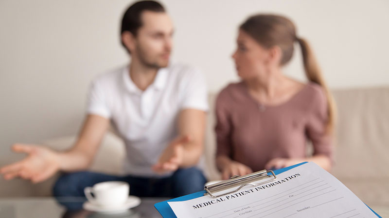 En man och en kvinna sitter i en soffa