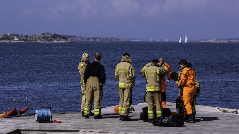Sex personer från räddningstjänsten står på en klippa i skärgården och förbereder sig för en insats