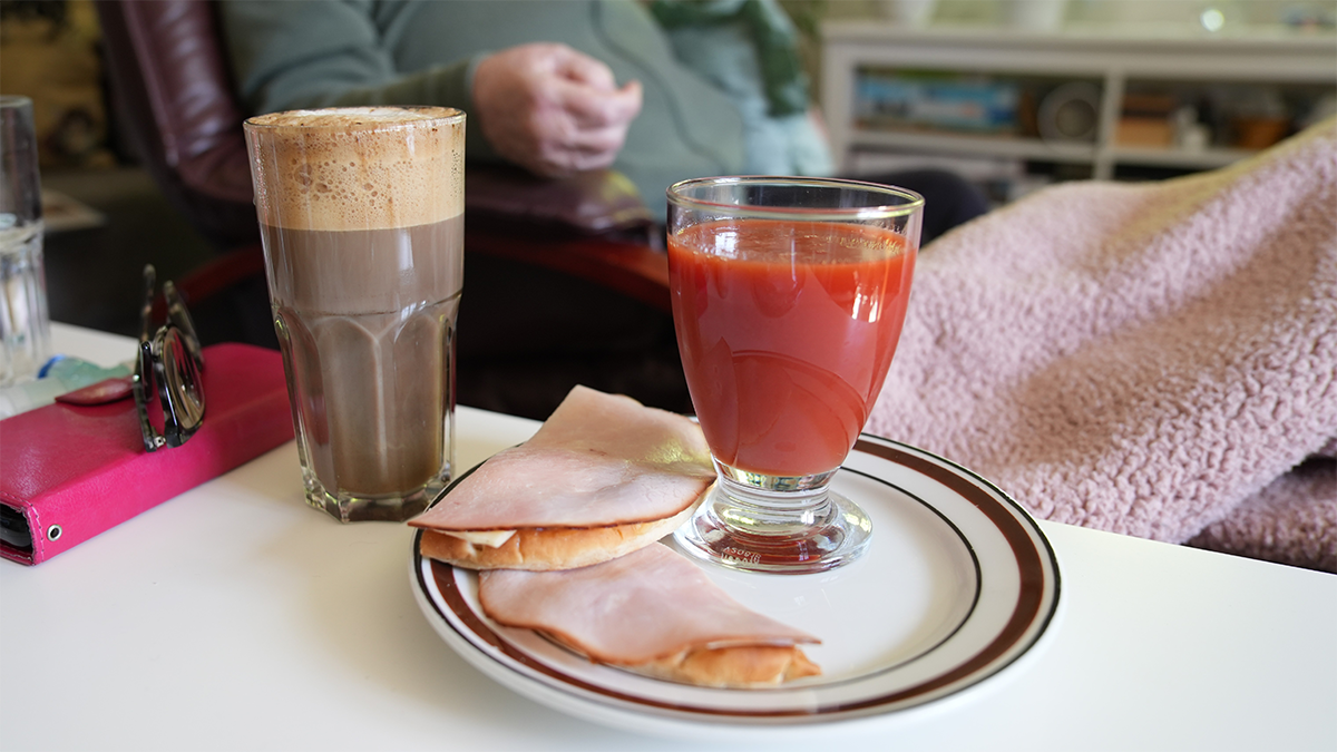 En frukostbricka med kaffe, juice och smörgåsar.