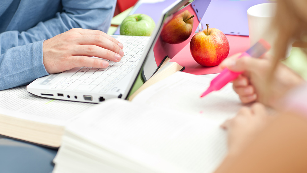 Personer som skriver på dator och på papper.