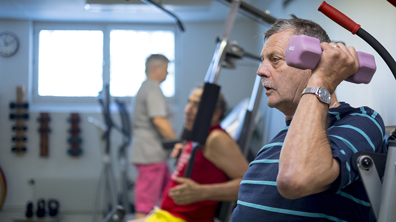 En man lyfter tyngder på ett gym